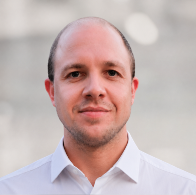 Porträt eines Mannes in weißem Hemd, der als HR Controller für die Digitalisierung von HR-Prozessen bei HR Metrics tätig ist.
